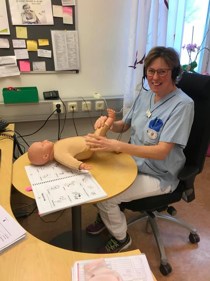 Bild på en sköterska som visar hur man utför spädbarnsmassage på en docka.